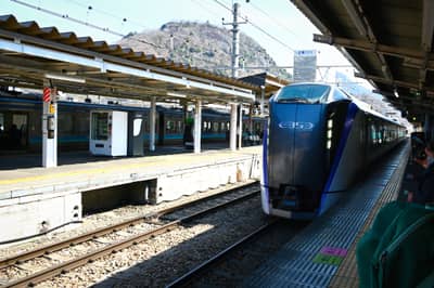 Blue Express Train at Railway Station with Mountain Backdrop