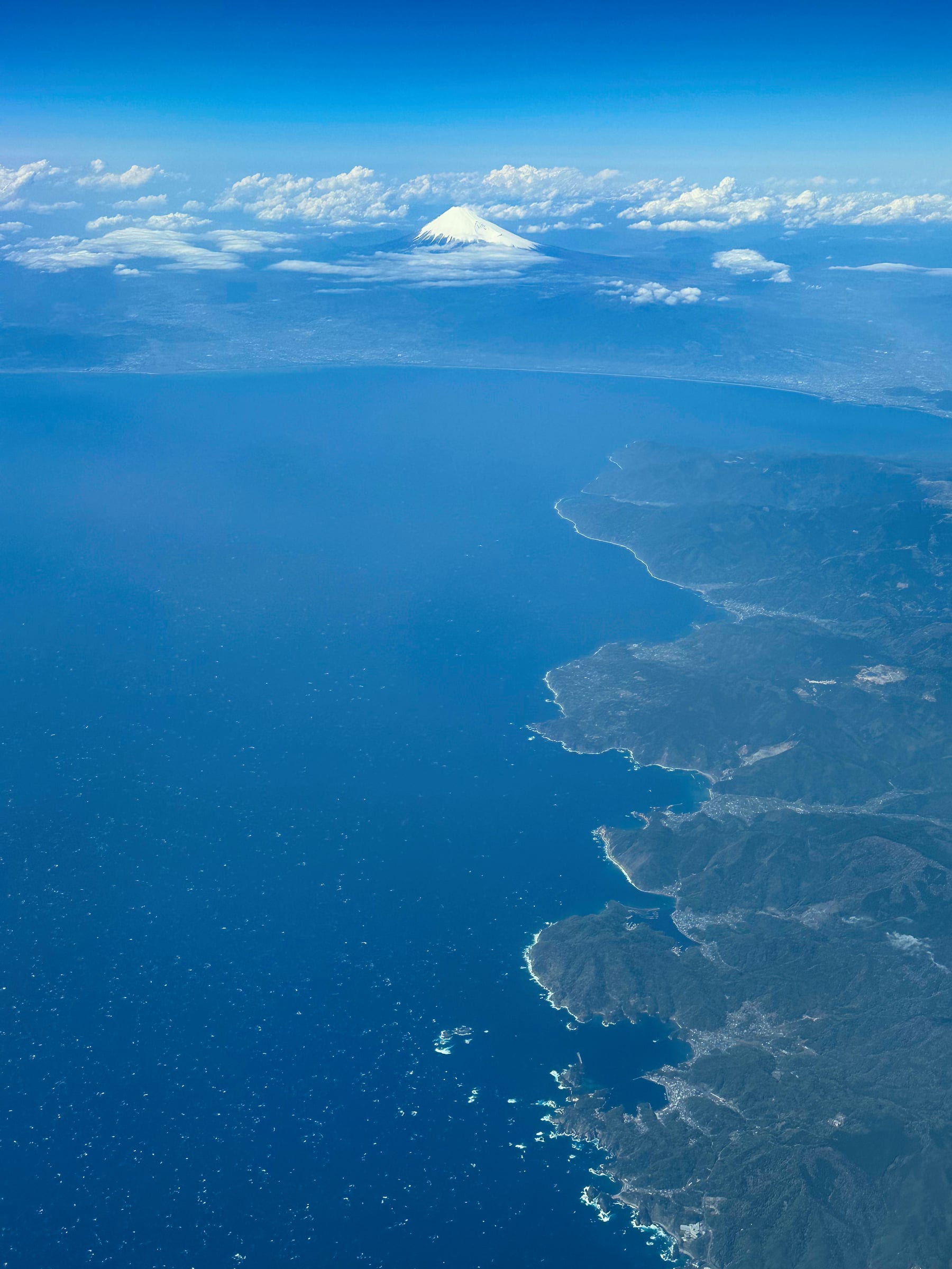 Aerial View of Mount Fuji Rising Above Coastal Clouds