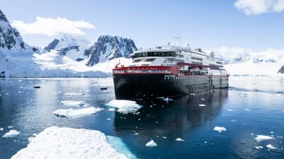 Expedition Cruise Ship Navigating Antarctic Waters at Pleneau Island